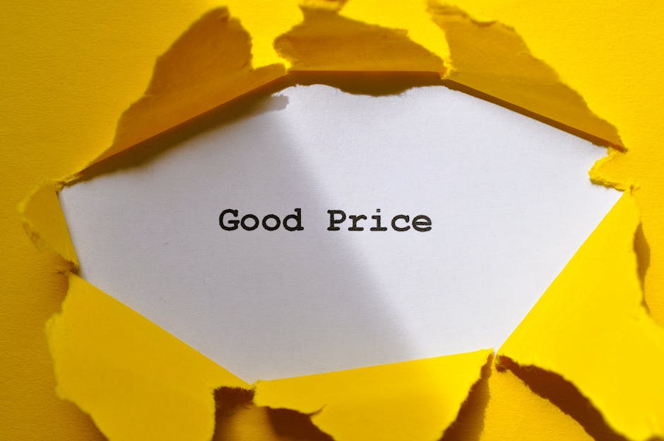 A piece of bright yellow paper with a torn edge reveals a white card underneath, displaying the words 'Good Price' in black typewriter-style font. The torn paper has rough, jagged edges, and the background is also yellow, creating a contrast that emphasizes the message. The composition is simple, focusing on the layered paper and clear text, suggesting affordability and value, relevant to a landscaping or garden maintenance context. This image is associated with Gardeners Marylebone, highlighting cost-effective garden services and pricing transparency.